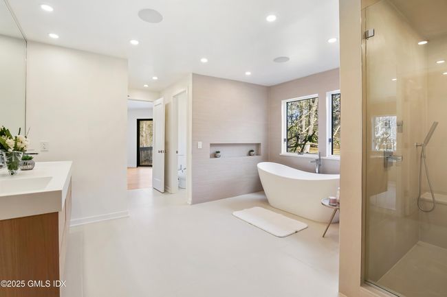 Luxurious comfort in spa like bathroom with shower, freestanding tub, bidet, and view of priv deck with hot tub | Image 29