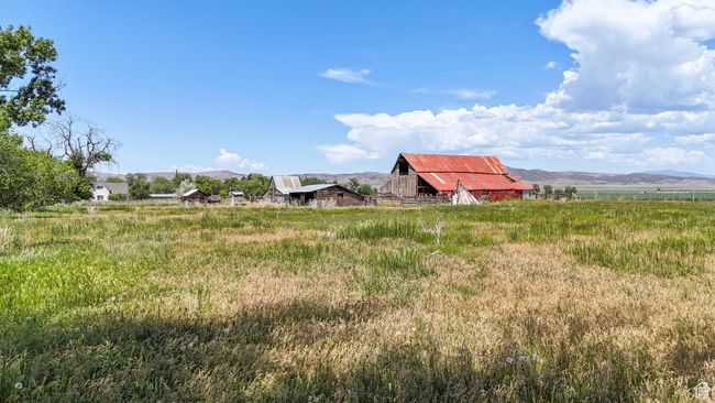 View of yard featuring a barn, a mountain view, and an outdoor structure | Image 10
