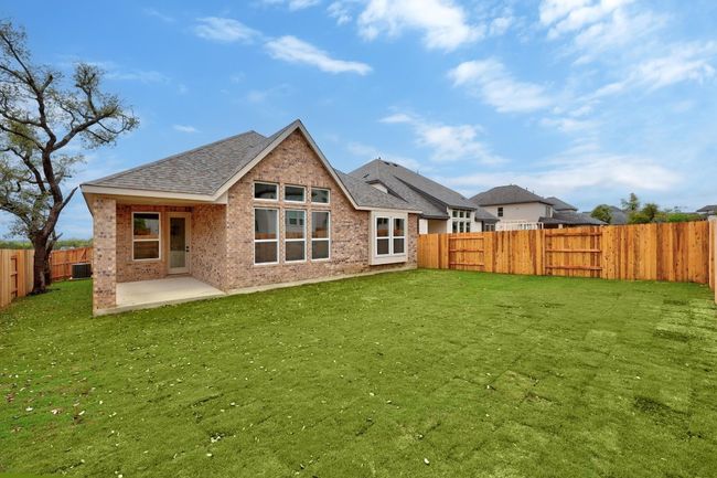 Rear view of house with brick siding, a fenced backyard, a shingled roof, and a patio | Image 22