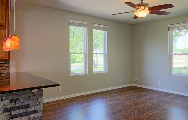 Spare room featuring baseboards, dark wood-style floors, and plenty of natural light | Image 6
