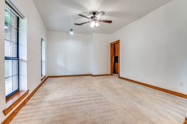 Spare room featuring healthy amount of natural light, carpet, and a ceiling fan | Image 7