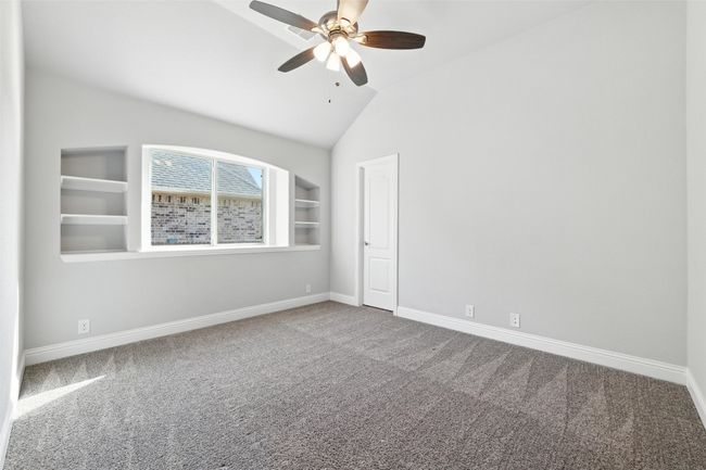 Carpeted empty room featuring lofted ceiling and a ceiling fan | Image 28