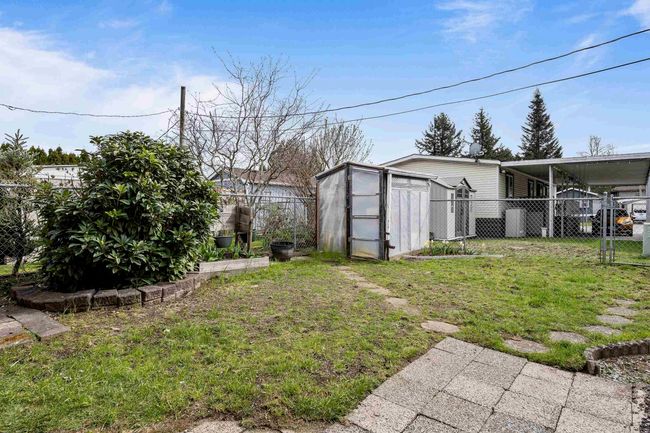 View of yard featuring an outbuilding, a storage unit, and a fenced backyard | Image 28