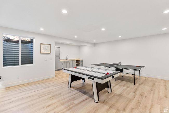 Rec room featuring light wood-style floors, a sink, baseboards, and recessed lighting | Image 39