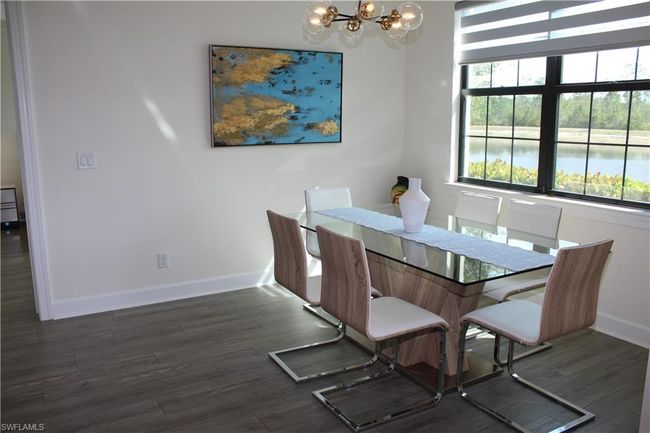 Dining room with baseboards, wood finished floors, and a notable chandelier | Image 10