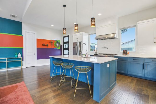 Kitchen with stainless steel fridge, wall chimney range hood, recessed lighting, dark wood-type flooring, and tasteful backsplash | Image 15