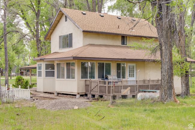 Rear view of house featuring roof with shingles and stucco siding | Image 7