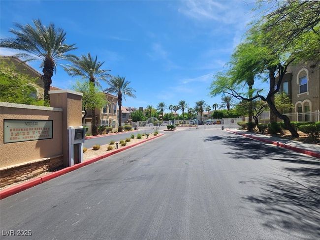 View of road with curbs, a gate, a residential view, and a gated entry | Image 33