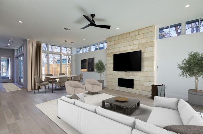 Virtually staged. The grand living/dining room is open to the kitchen. A wall of windows by the dining area makes the entire first floor feel interconnected yet private from neighbors. | Image 12