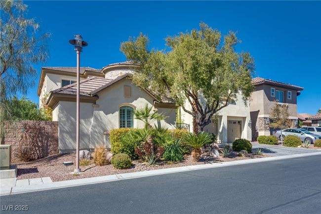 Mediterranean / spanish-style home with a tile roof, concrete driveway, stucco siding, and fence | Image 4