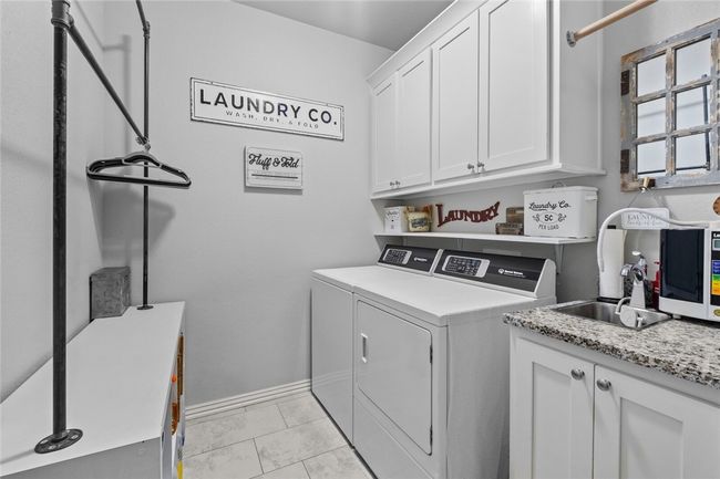 Large laundry room with sink and plenty of storage. | Image 29
