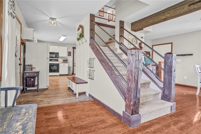 Stairs featuring a toaster, wood finished floors, and baseboards | Image 7