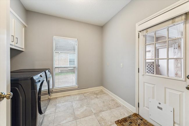 The 9’x9’ utility room is located downstairs off the kitchen and has a door opening to the breezeway, covered patio, and back yard. | Image 31
