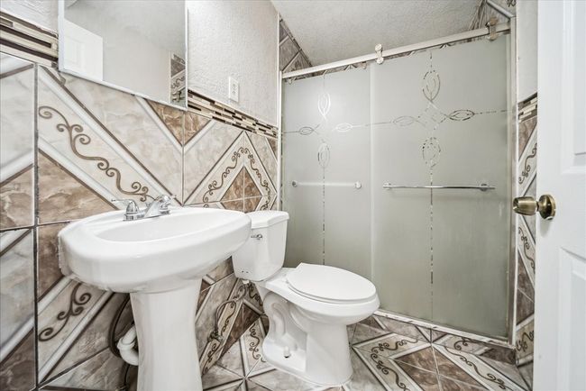 Full bathroom with a shower stall and a textured ceiling | Image 16