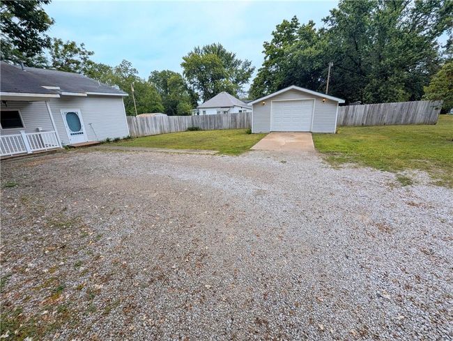 View of yard featuring concrete driveway, an outdoor structure, and a detached garage | Image 5