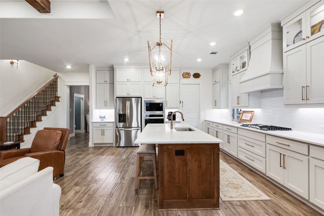 Kitchen with appliances with stainless steel finishes, a sink, premium range hood, recessed lighting, and open floor plan | Image 13