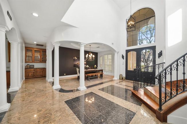 Arched openings & columned entrances leads to the living spaces of the home. Convenient for guests, a half bath is located nearby. | Image 4