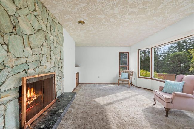 Sitting room featuring a textured ceiling, carpet floors, a fireplace, and baseboards | Image 17