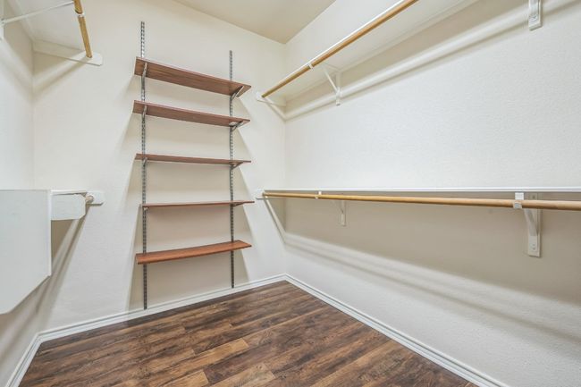 The private primary suite boasts tall ceilings, a ceiling fan, and a luxurious en-suite bathroom complete with a double vanity, garden soaking tub, separate shower, and a large walk-in closet. | Image 19