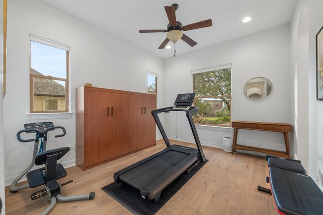 Exercise area featuring a ceiling fan, light wood-style flooring, and recessed lighting | Image 24