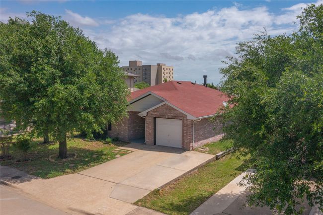 View of front of house featuring concrete driveway, a garage, and brick siding | Image 5