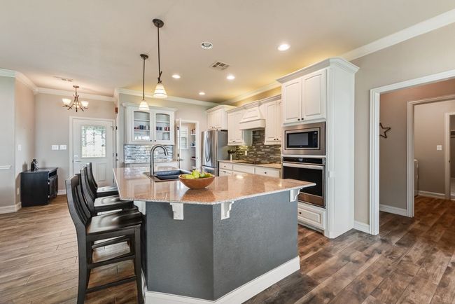 The kitchen features a large island with bar seating. | Image 11