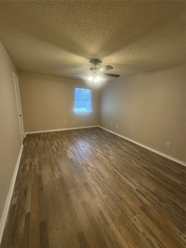 Empty room featuring dark wood-style floors, baseboards, and ceiling fan | Image 10