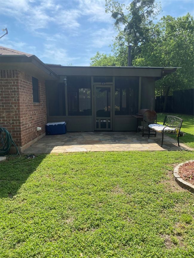 Rear view of house with fence, a yard, a patio, brick siding, and a sunroom | Image 21