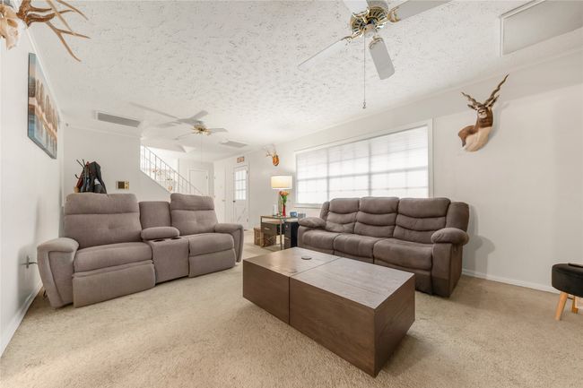 Spacious Living room featuring staircase, carpet floors and ceiling fans | Image 4