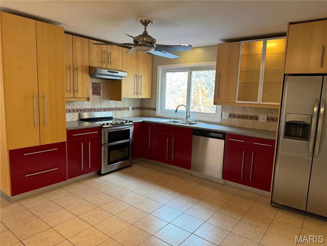 Kitchen featuring ceiling fan, sink, backsplash, and appliances with stainless steel finishes | Image 7