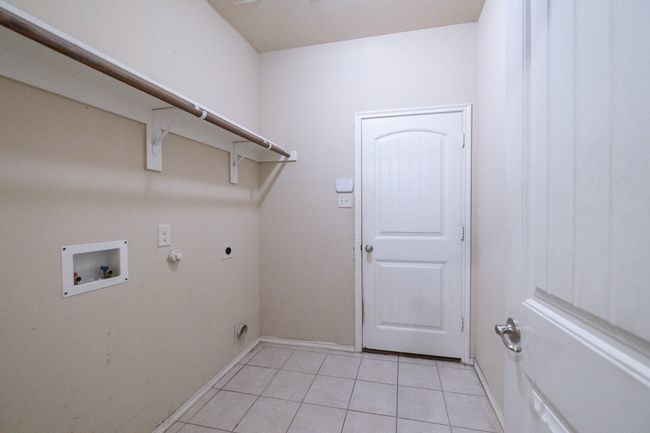 Laundry room with electric dryer hookup, hookup for a washing machine, light tile patterned floors, and hookup for a gas dryer | Image 30