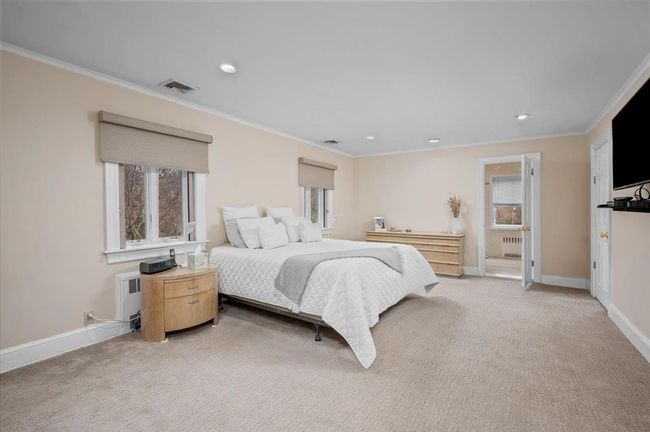 Bedroom featuring visible vents, radiator heating unit, and crown molding | Image 11
