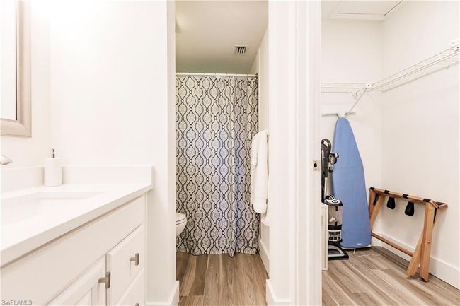 Bathroom with wood finished floors, vanity, a shower with curtain, toilet, and visible vents | Image 18
