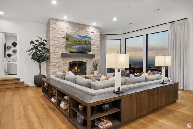 Living room with light wood-type flooring, a stone fireplace, and recessed lighting | Image 17