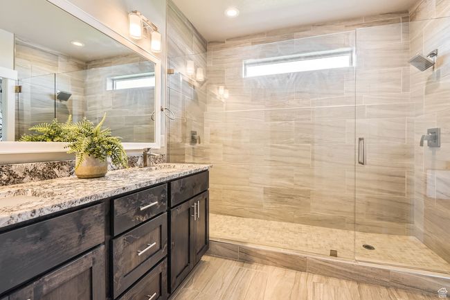 Bathroom featuring double vanity, a shower stall, plenty of natural light, and recessed lighting | Image 13