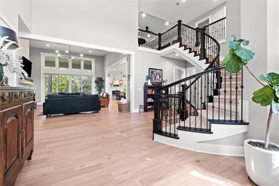 Foyer featuring a chandelier, a high ceiling, and light hardwood / wood-style flooring | Image 1