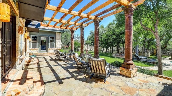 View of flagstone patio / terrace featuring a pergola and metal arches over exit doors | Image 39