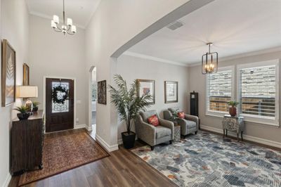 Foyer with a view of the dining room space being used as a second living area | Image 3