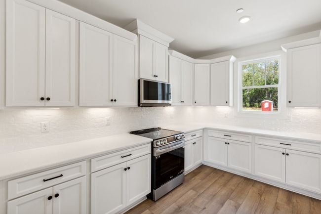 Soft-close cabinets and drawers, dovetail joinery, quartz countertops, upscale kitchen backsplash, under cabinet lighting, upgraded appliances, and even natural light from your window! Actual photo of home. | Image 13