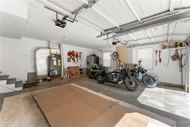 Garage featuring heating unit, stainless steel fridge, and a garage door opener | Image 39