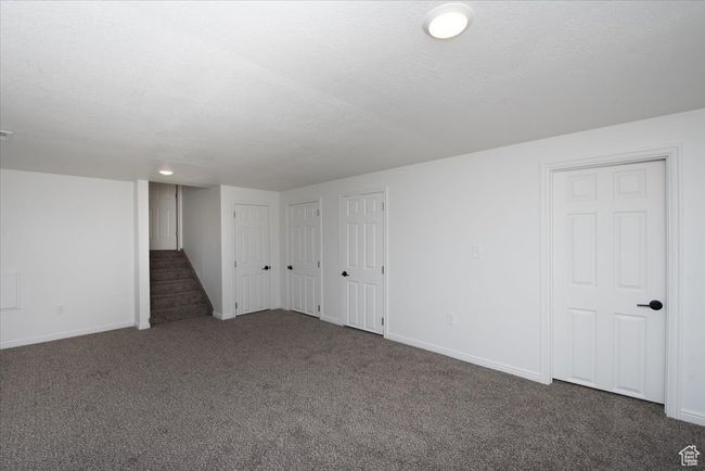 Basement with baseboards, carpet, and stairway | Image 25