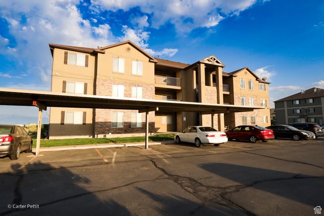 View of building exterior with covered and uncovered parking | Image 6