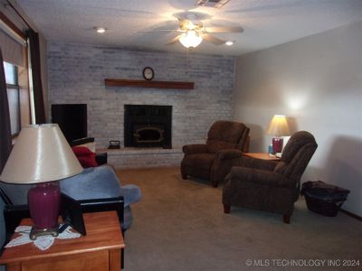 living area with wood burning fireplace | Image 2