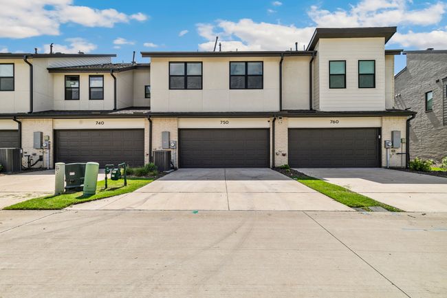 View of property featuring an attached garage, driveway, central air condition unit, and brick siding | Image 31