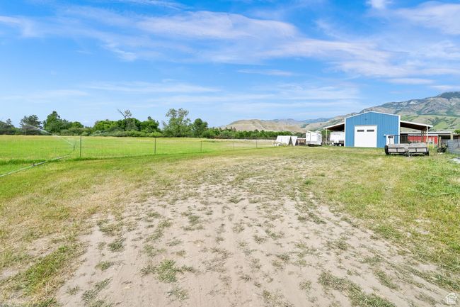 View of yard featuring a garage, a mountain view, an outdoor structure, a view of countryside, and driveway | Image 57