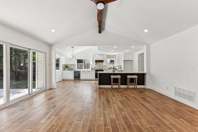 Exposed beams and expansive windows flood the living area with natural light. | Image 12