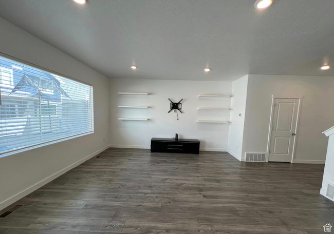 Unfurnished living room with dark wood-style floors and recessed lighting | Image 5