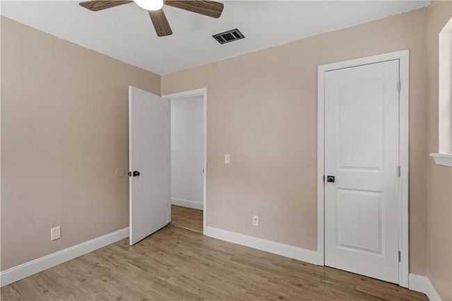 Unfurnished bedroom with visible vents, ceiling fan, baseboards, and wood finished floors | Image 18