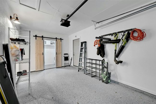 The 1-car garage features an upgraded light fixture and upgraded epoxy flooring throughout. | Image 28