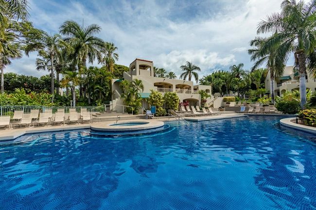 There is ample space for lounging on the long tiled deck that wraps around the pool & spa area | Image 35